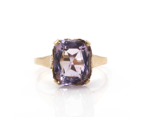 A 9ct gold single stone amethyst ring,  with a scissor cut amethyst, four claw set at the cut corners to a pierced heart coll