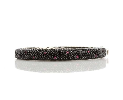 An 18ct white gold black gemstone and ruby pavé set hinged 'Fantasia' bangle, by Roberto Coin, c.2005, a tapered top half pav