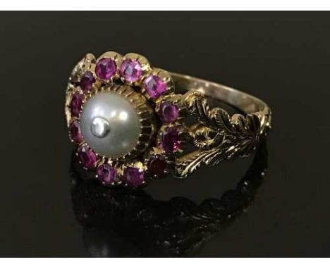 A ruby and pearl cluster ring, the central pearl surrounded by a ring of rubies within a chased yellow gold setting, 4.1g