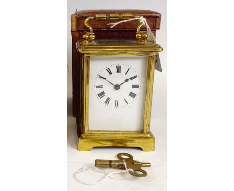 A carriage clock, with an enamel dial, in a brass case, 15 cm high, in a leather travelling case