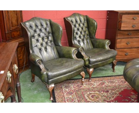 A pair of Chesterfield button upholstered wingback office chairs.