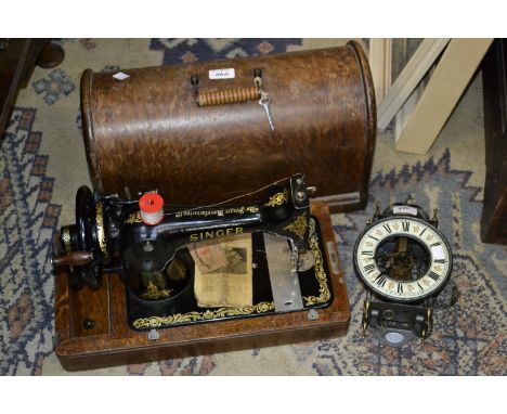 A vintage Singer Hand operated sewing machine, portable oak case; a lantern clock (2)