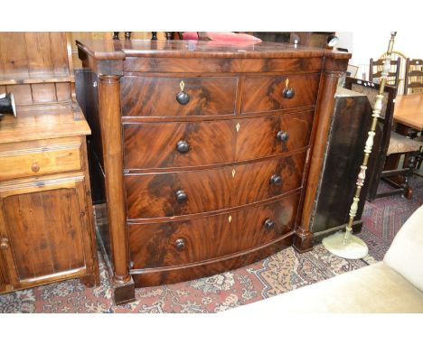 A Victorian mahogany bow fronted split chest of drawers, oversailing top, two short cockbeaded drawers over three graduated l