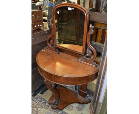 A Victorian mahogany bow front Duchess dressing table, arched mirror with carved scroll supports, acanthus carved cabriole fo