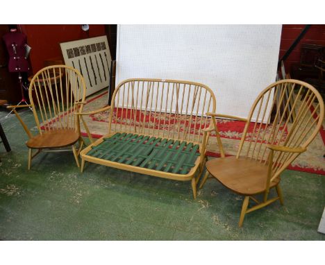 An Ercol light elm three piece suite comprising two seat spindle back settee and two armchairs.