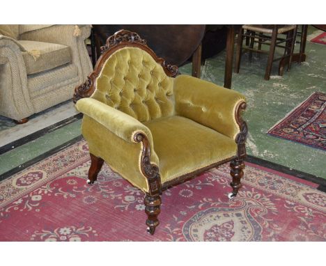 A Victorian mahogany armchair, arched back with pierced and carved cresting top rail, button upholstered, scrolling padded ar