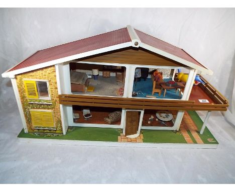 A vintage Toy Works Ltd oak leaf dolls house, over two floors with balcony, internal light fittings, carpets, furniture and p