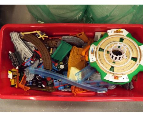 A plastic chest containing a large amount of Thomas the Tank Engine trains, track and accessories