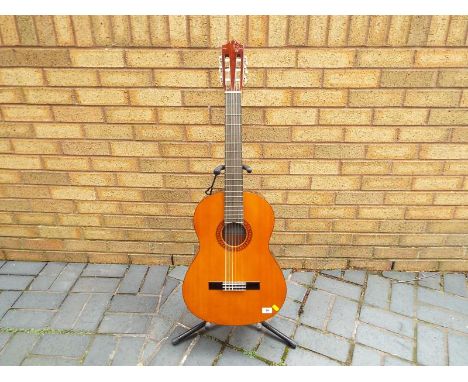 A Yamaha classical guitar, model number CG100A, with soft case, pitch pipe, and books - Est £30 - £50