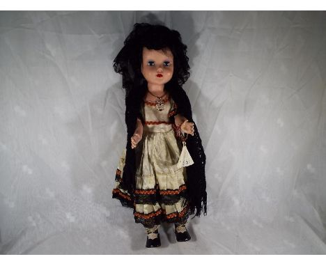 A vintage dressed doll with jointed limbs, with sleeping eyes, marked to the back of the body D.I.L. also displayed on back p