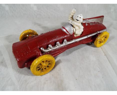 A cast iron novelty red racing car in the form of a 1934 Hubley marked Michelin with a depiction of the Michelin man within, 