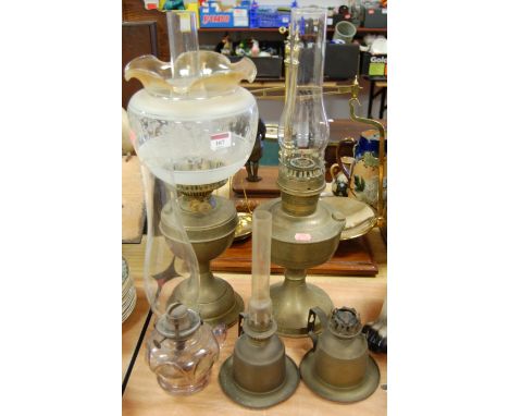 An early 20th century brass pedestal oil lamp with etched glass shade, together with four others (5)