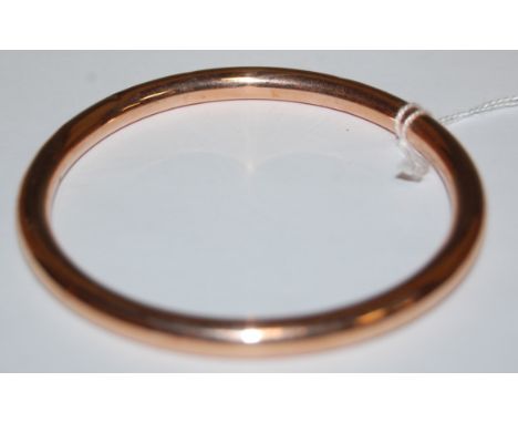 A yellow metal hollow bangle, indistinctly marked, 15.7g