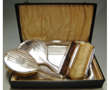 An engine turned silver dressing table set comprising; tray, pair of clothes brushes, hairbrush, mirror and comb