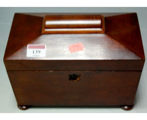 A Victorian mahogany tea caddy of sarcophagus form on bun feet 