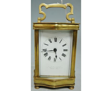 An early 20th century French lacquered brass carriage clock of serpentine form, having a white enamel dial with Roman numeral