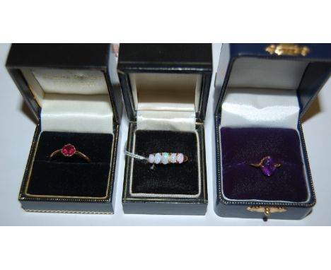 A ladies 14ct gold and opal set dress ring; and two other yellow gold and semi-precious set dress rings (3)