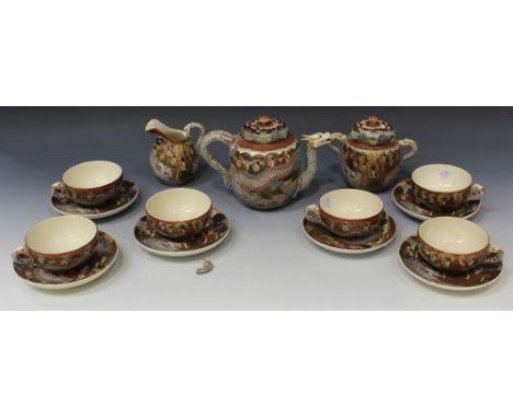 A Japanese Satsuma earthenware part tea set, Meiji period, comprising teapot and cover, sugar bowl and cover, milk jug, six c