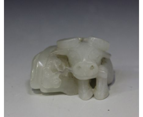 A Chinese Peking glass imitating white jade figure of a water buffalo, Qing dynasty, modelled in a recumbent pose holding a l