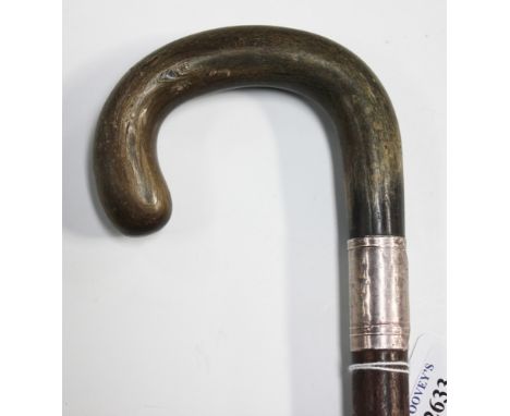 An early 20th Century horn handled walking stick, probably rhino horn, the curved handle above a silver collar and rosewood s