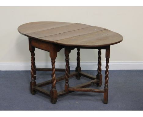 A 19th Century oak oval drop-flap supper table, raised on barley twist and block legs, height approx 65cm, length approx 135c