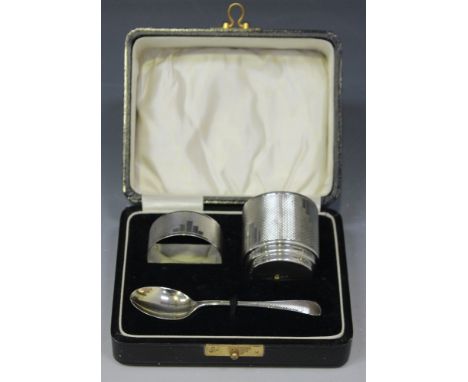 An Art Deco silver three-piece christening set, comprising egg cup, napkin ring and spoon, each with engine turned decoration