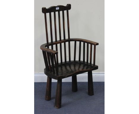 A late 19th/early 20th Century oak stick and comb back Windsor armchair with a solid seat, raised on chamfered block legs, he