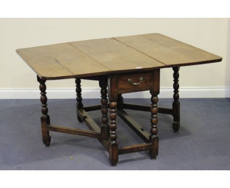 An early 18th Century fruitwood drop-flap rectangular dining table, the frieze fitted with a single drawer, raised on bobbin 