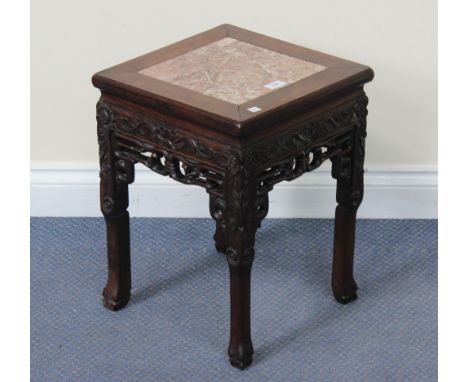 A Chinese hardwood jardinière stand, late 19th Century, the square top inset with a rouge marble panel above a carved lotus f