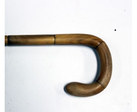 A late 19th Century rhino horn handled walking stick with a sectional curved handle and elongated collar, length approx 89cm.