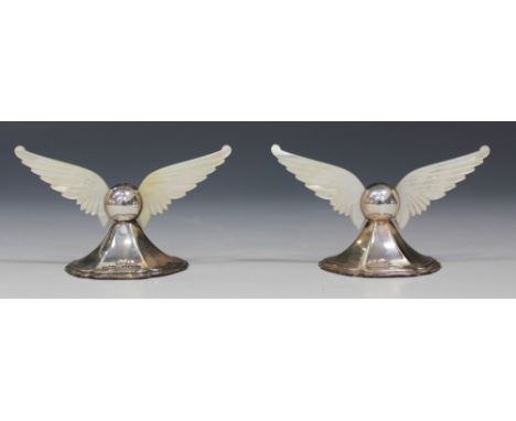 A pair of George V silver knife rests, each with a pair of carved mother-of-pearl wing supports, on a hexagonal base, Sheffie