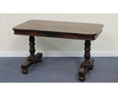 A Regency rosewood library table, the rectangular top above two concealed frieze drawers and a beaded edge, raised on a pair 