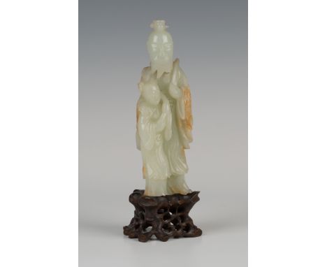 A Chinese pale celadon jade sectional figure of a scholar and attendant boy, Qing dynasty, modelled standing side by side wea