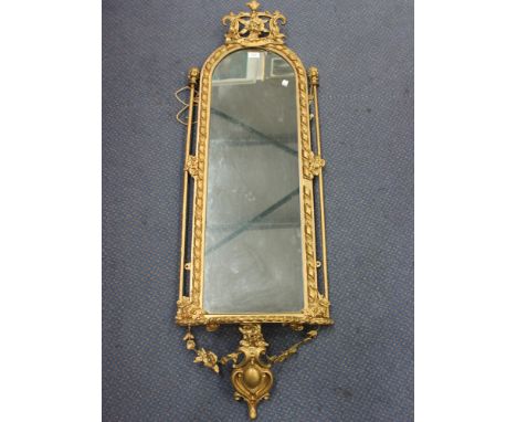 A 19th Century gilt painted pier mirror, the arched frame with a foliate scrolling surmount above a shelf apron with cartouch