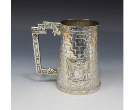 A South American sterling tankard, decorated in relief with a seated figure playing a pipe and a llama, detailed 'San Judas 9