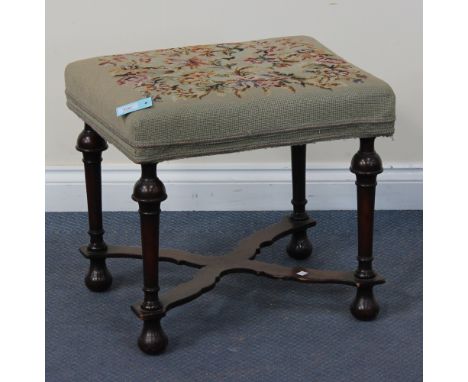 A late 19th/early 20th Century William and Mary style mahogany stool with a tapestry seat, raised on turned legs united by an