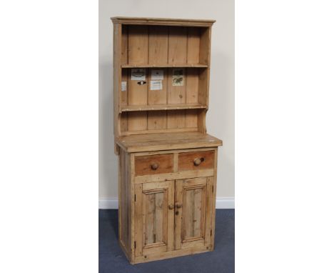 A 20th Century stripped pine narrow dresser, the shelf back above two drawers and panelled cupboards, height approx 180cm, wi