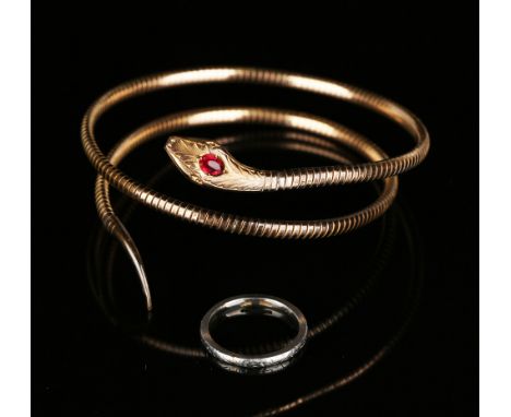 A platinum wedding ring, ring size approx O, and a red paste set sprung bangle, designed as a coiled snake.