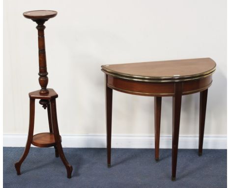 A late 19th Century walnut fold-over demi-lune card table, raised on square tapering legs and brass mounted feet, width appro