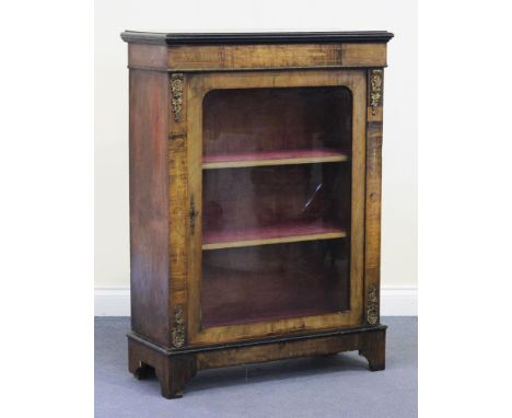 A Victorian walnut pier cabinet with applied gilt metal mounts, the moulded top above a glazed door, on bracket feet, height 