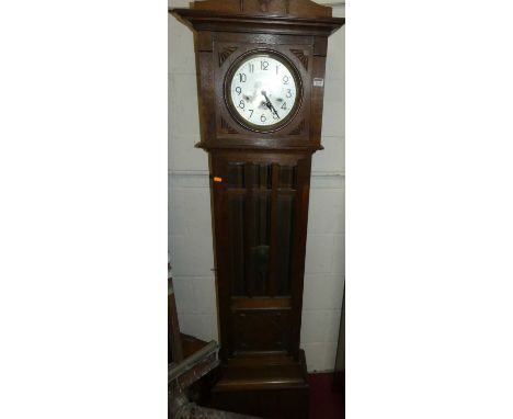 A 1920s oak longcase clock, having an unsigned silvered dial and three-train striking and chiming movement