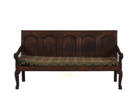 An 18th century oak panelled back settle, with a solid seat and a liberty printed cushion, 184cm wide