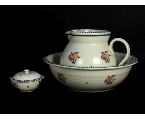 A Poole Pottery wash basin, ewer and soap dish, decorated with floral sprays