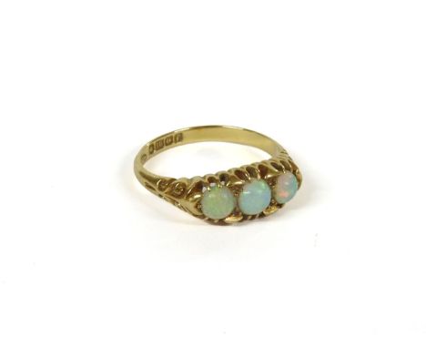 An Edwardian 18ct gold boat shaped three stone opal ring, with scroll shoulders, Birmingham, 1905