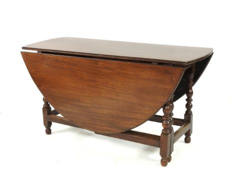 A mahogany top gate leg table, raised on a walnut and oak stand, 141cm long