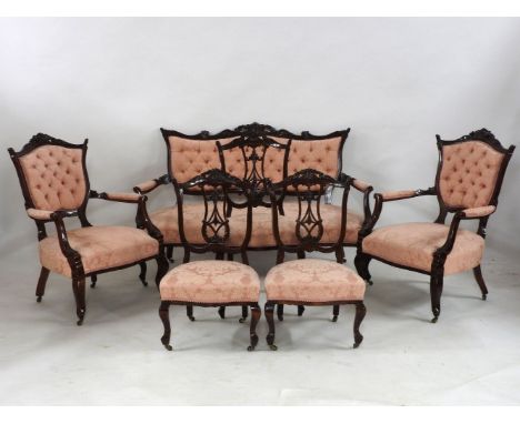 An Edwardian mahogany suite, comprising a two seater sofa, a pair of chairs, a pair of nursing chairs, and a single chair