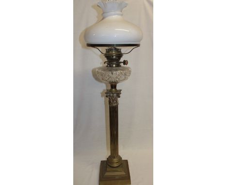 A brass Corinthian column oil lamp by Hinks & Co. with cut-glass reservoir and opaque glass shade