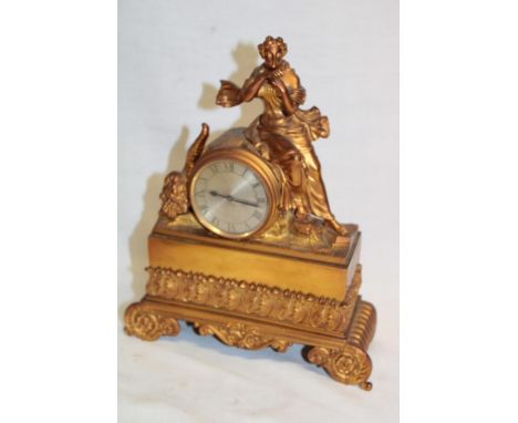 A French mantel clock with silvered circular dial in brass tapered case decorated with a seated female figure 9 1/2" high