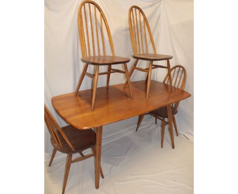 A 1960's Ercol light elm rectangular dining table on tapered legs, 58" long together with a set of four light elm spindle-bac