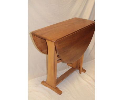 A 1970's Ercol light elm oval drop-leaf dining table on standard supports, 42" x 33"